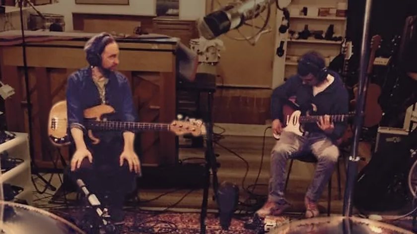 A live tracking room: Alex on bass and a guitarist, both in headphones.