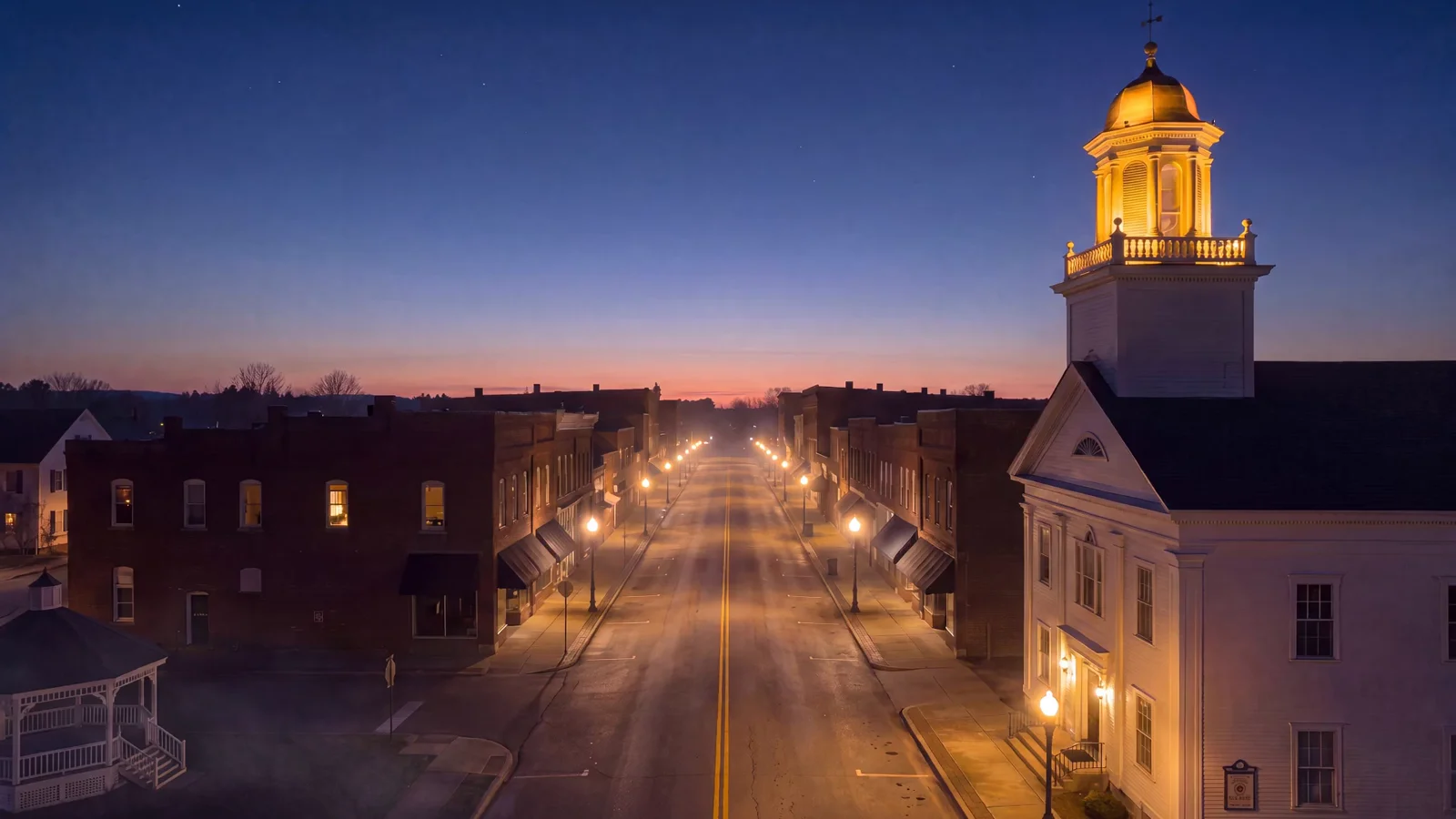 Film still: a small town from the air at dusk.