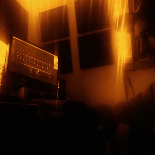 A home studio late at night, lit amber: a synthesizer by the window.
